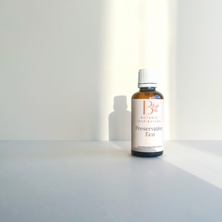 An amber glass bottle sits on a white surface. The label reads Preservative Eco. The label is a light neutral colour with a logo. The logo  is pink. This preservative can be used in natural skincare formulations and can be purchased in Australia