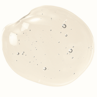 a drop of coco glucoside is on a white surface. It is a light beige colour and there are a couple of foam bubbles in the centre of the coco glucoside drop