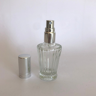 An empty glass perfume bottle with the lid off