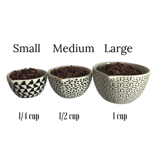 3 measuring bowls that are white with black patterns. Each bowl is filled with dried flowers. 