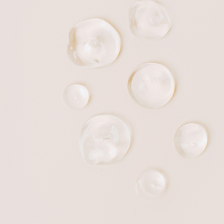 Small droplets of Preservative Eco or Geogard ECT are on a plain background. This preservative is suitable for natural skincare formulations and can be purchased in Australia 