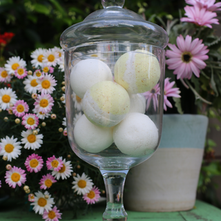 A glass vase holds 6 bathbombs that have been created using bath bomb spheres